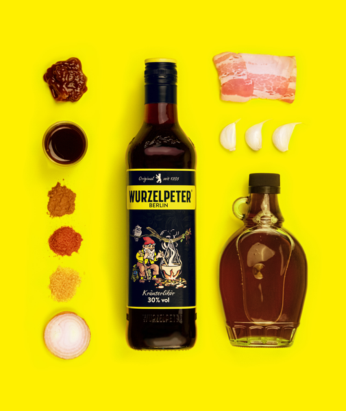 Auf dem Bild sind Gewürze, Knoblauch, Speck und eine Flasche Wurzelpeter in einer bunten Anordnung zu sehen.